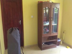 une armoire en bois dans une pièce dotée d'un mur jaune dans l'établissement Lagoon Apartments Beruwala, à Beruwala