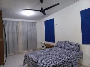 a bedroom with a bed and a ceiling fan at CASA ALTABRISA in Mérida
