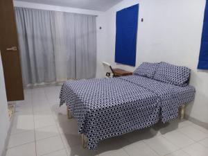 a bedroom with a bed and a table and a window at CASA ALTABRISA in Mérida