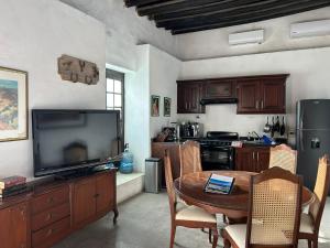 a kitchen with a table and a television and a table and chairs at La Casita de Carranza in Cuatrociénegas de Carranza