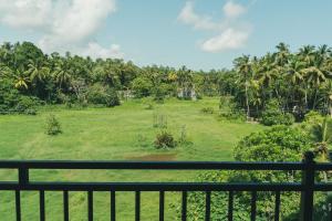 a view of a lush green field from a balcony at Leyon Paradise Hotel in Unawatuna