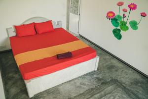 a bedroom with a bed with red pillows at Leyon Paradise Hotel in Unawatuna