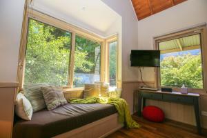 een kamer met een bank voor een raam bij Alpine Arnica Cottage 2 in Harrietville