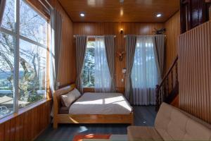 - une chambre avec un lit et une grande fenêtre dans l'établissement Tường Vy Homestay Đà Lạt, à Đà Lạt