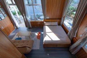 Tường Vy Homestay Đà Lạt في دالات: غرفة صغيرة بها سرير وأريكة