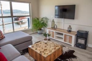 sala de estar con sofá y TV en Laguna Grove 14 en Knysna