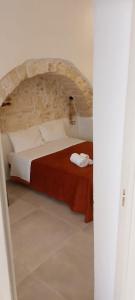 オストゥーニにあるDimora Lavinia Casa vacanze Centro storico Ostuniの石壁のベッドルーム1室(大型ベッド1台付)