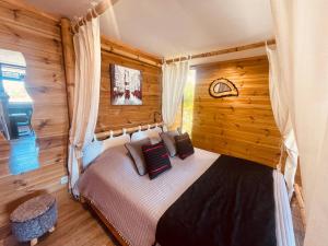 ein Schlafzimmer mit einem Bett in einem Blockhaus in der Unterkunft Gîte Paradis Lé La in L’Étang-Salé