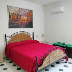 a bedroom with a red bed with a painting on the wall at Il giardino di Emilia in Raviscanina