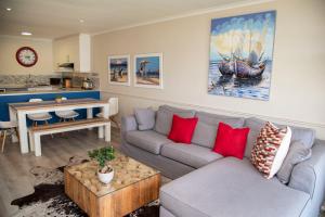 uma sala de estar com um sofá e uma mesa em Laguna Grove 14 em Knysna