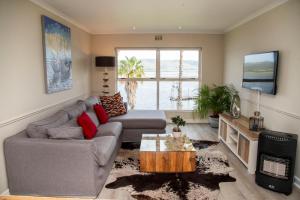 a living room with a couch and a tv at Laguna Grove 14 in Knysna