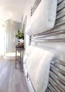 a towel rack with white towels on it in a bathroom at Ironbridge View Townhouse - Stunning view of the Iron Bridge UK WINNER 2024 'MOST PICTURESQUE SELF-CATERING HOLIDAY HOME' of the year' & WINNER '2024 BEST HOLIDAY HOME IN SHROPSHIRE' in Ironbridge