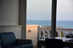 a room with a view of the ocean through a window at Terrazze Naos in San Leone