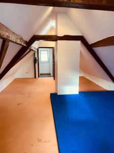 a attic room with a blue table and a window at Gemütliches freistehendes Haus in der Nähe von Frankfurt in Kelkheim