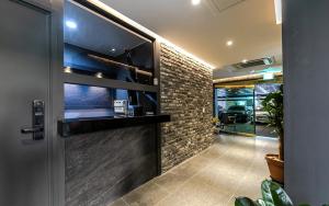 a lobby with a door and a brick wall at Hotel Yaja Terminal Branch in Jeonju