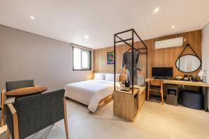 a hotel room with a bed and a desk at Hotel Yaja Terminal Branch in Jeonju