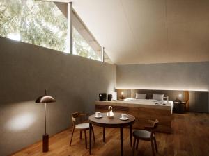 箱根町にあるHakone Retreat villa 1fのテーブル、椅子、ベッドが備わる客室です。
