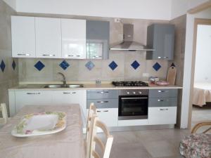 a kitchen with white cabinets and a table with a plate at Vivere il mare in Palinuro +7 photos