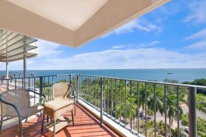 a balcony with chairs and a view of the ocean at Sky-high Waterfront Living across Two Apartments in Darwin