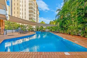 a swimming pool in a building with a resort at Sky-high Waterfront Living across Two Apartments in Darwin