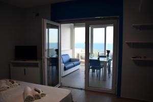 a bedroom with a door open to a room with a chair and a table at Terrazze Naos in San Leone