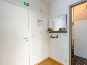 een witte kamer met een deur en een spiegel bij Apartment on the 8th floor with terrace in Middelkerke