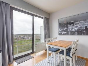 een eetkamer met een tafel en stoelen en een groot raam bij Apartment on the 8th floor with terrace in Middelkerke
