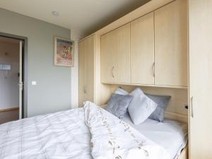 een slaapkamer met een bed met witte lakens en blauwe kussens bij Apartment on the 8th floor with terrace in Middelkerke