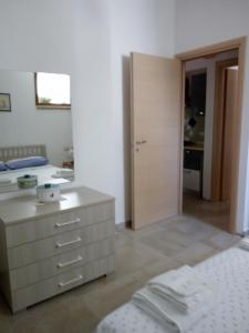 um quarto com uma cama, uma cómoda e uma porta em Vivere il mare em Palinuro
