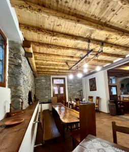 a dining room with a table and a stone wall at Agriturismo La Vecchia Chioderia in Grandola ed Uniti