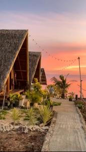 ein Resort am Strand mit Sonnenuntergang im Hintergrund in der Unterkunft KADIJ Guest House in San Juan