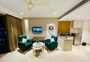 - un salon avec deux chaises vertes et une table dans l'établissement Luxury Studio with Patio by Tulip Homes, à Gurgaon