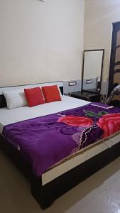 een slaapkamer met een groot bed met rode kussens bij RESIDENCE TULSI in Vrindāvan