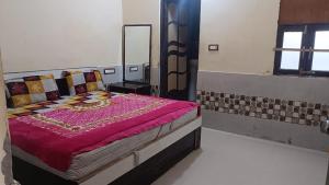 a bedroom with a bed with a purple blanket at RESIDENCE TULSI in Vrindāvan