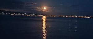 a moon reflecting in the water at night at Pearl kokkonaki in Kokóni