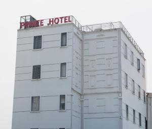 Un hôtel blanc avec un panneau rouge en haut dans l'établissement Prince Hotel, à Hô-Chi-Minh-Ville