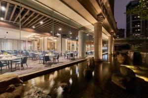 un restaurante con mesas y sillas en un edificio en Miramar Garden Taipei, en Taipéi