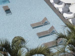 an overhead view of a pool with lounge chairs and palm trees at Yeosu Calacatta Hotel & Resort in Yeosu