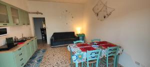 uma cozinha com uma mesa e um sofá num quarto em L'ulivo di Alice em Marsala