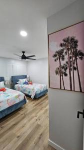 a bedroom with two beds and a ceiling fan at Hoʻonānea I Loko Kailua in Kailua