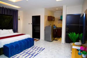 a bedroom with a large bed and a kitchen at U3 Studio Apartment in Lagos