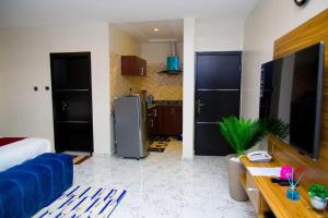 a living room with a blue couch and a kitchen at U3 Studio Apartment in Lagos