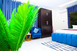 a bedroom with a blue bed and a blue chair at U3 Studio Apartment in Lagos