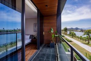 um quarto com uma varanda com vista para a água em LUXURY VILLA with 5 BEDROOMS RIVER VIEW em Da Nang