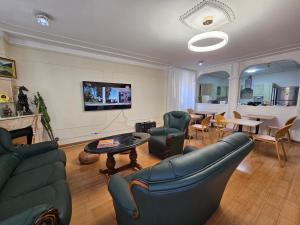 uma sala de estar com um sofá, cadeiras e uma mesa em Moncozy guest house em Ulan Bator