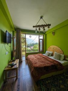 um quarto com uma cama grande e uma janela em Attic Monkey Cafe & Rooms em Manali