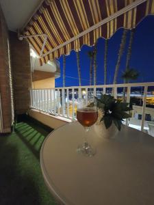 una copa de vino sentada en una mesa en un balcón en Adorable Apartamento en la Playa, en Puerto de Mazarrón