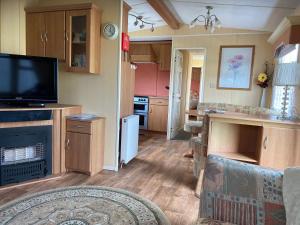 a living room with a television and a kitchen at 18 Gannet Grove Haven thornwickbay Flamborough Bridlington east coast in Flamborough