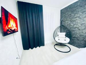 a room with a wicker chair and a fireplace at Like Home Hostel na Shevchenko, 162Б in Almaty