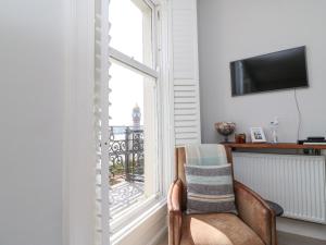 a living room with a chair and a window at Sunrise Apartment in Weymouth